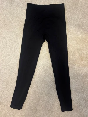 Svarta scrunch tränings tights  - Säljer ett par svarta leggings med scrunch-detalj bak och hög midja. De är tighta och har en elastisk passform. 