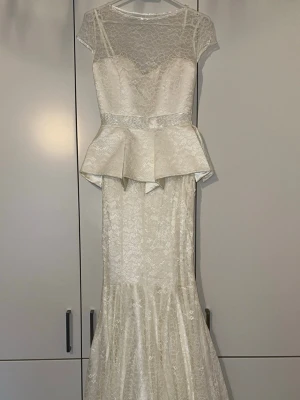 Otroligt vackert vit klänning | Nytt skick - Aldrig använt.  Den är verkligen sjukt fin men för liten för mig. Passar perfekt till en fest /bröllop/bal…Elegant, klänning med spetsdetaljer. Klänningen har en figurnära silhuett med en utsvängd kjol nedtill. Den övre delen av klänningen har en vacker spetsdesign och en markerad midja med en dekorativ detalj.