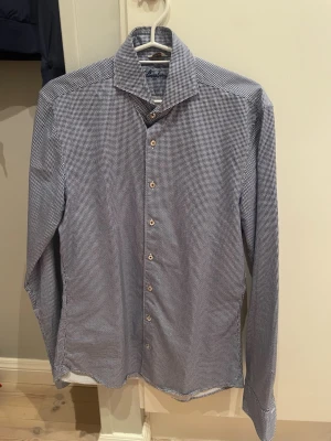 Slimline blåvit rutig skjorta Stenströms - Snygg blåvit skjorta från Stenströms i slimline-passform. Rutigt mönster, klassisk krage och ljusa knappar framtill. Långärmad med broderad logga på manschetten. Perfekt för dig som gillar stilrena detaljer och en modern look. Köpte på NK och har endast använts en gång.