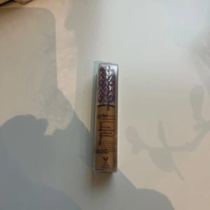 Tarte Shape Tape Concealer 38N - Shape Tape Concealer från Tarte i färgen 38N medium-tan neutral. Kommer i en smidig tub med lila och guldmönstrad kork. Perfekt för att täcka mörka ringar och ojämnheter med en neutral underton. Vegansk formula.