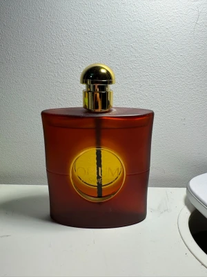YSL Opium parfymflaska - En ikonisk parfym från Yves Saint Laurent med en unik och elegant flaska. Perfekt för dig som vill sticka ut och addera lite lyx till din samling. 