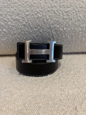 H-bälte - Ett svart H-bälte perfekt för dig som gillar mode och stil, bältet har ett H med färgen silver och är ett fint märke och ett välkänt märke från Frankrike Paris. Kom dm för eventuella frågor 🧐pris kan diskuteras 💯. 