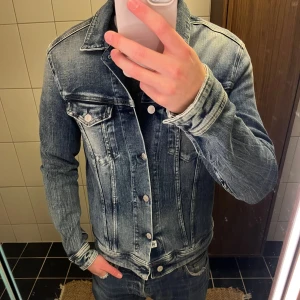 Blå jeansjacka från Replay - Säljer en snygg blå jeansjacka från Replay. Jag är 187cm och 75 kg. Den är L men skulle säga den sitter mer som M