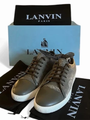 Lanvin sneakers st 42 - Äkta lanvin sneakers i storlek 42, skick är 7/10 och finns spår av använding, de kommer med sina 3 dustbags, låda och extra snöre. Skriv vid någon fundering