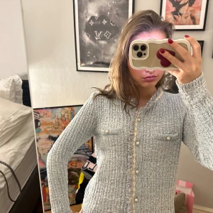 Ljusblå kofta från mango med pärlknappar - Superfin ljusblå kofta från mango med stickad struktur, dekorativa pärlknappar och fransiga detaljer längs kanterna. Koftan har två bröstfickor och lång ärm, perfekt för lager-på-lager under hösten eller våren.