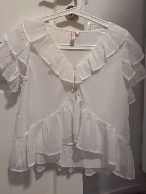 Vit blus - En elegant vit blus, går att matcha med ett par snygga byxor på ett speciellt event eller en normal vardag.