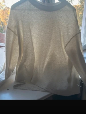 Vit stickad tröja från H&M Divided - Mysig vit stickad tröja från H&M Divided i storlek M. Tröjan har rund hals, ribbade muddar och lång ärm. Perfekt för lager-på-lager och chill dagar. Enkel och stilren design som funkar till många olika outfits.