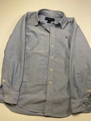 Ljusblå skjorta från Ralph Lauren - Storlek : 10 passar 148/156 | skick 7/10 | pris kan diskuteras vid snabb affär |