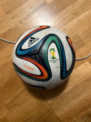 Adidas Brazuca VM 2014 fotboll - Säljer en Adidas Brazuca fotboll från VM 2014 i Brasilien. Perfekt för dig som älskar fotboll och vill ha en ikonisk boll från ett klassiskt mästerskap. Officiell matchboll med samlarvärde