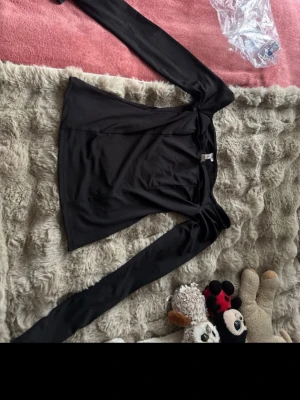 Svart långärmad topp från Nelly - Helt ny svart tajt tröja från Nelly. Den har ett skönt material och passar bra till alla olika sorters byxor/jeans.  Den har en silver detalj och sitter väldigt fint.  I storlek M