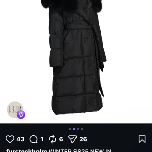 Svart lång pufferjacka med päls - Säljer en svart lång pufferjacka från Fur Stockholm med fluffig päls runt kragen och bälte i midjan. Jackan har quiltad design och omlottstängning, perfekt för kalla dagar. Stilsäker och varm look för vintern. Den är också helt ny och oanvänd. 