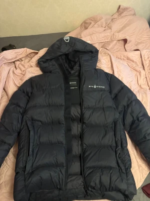 Svart Sail Racing jacka - Svart pufferjacka från Sail Racing med huva och dragkedja framtill. Pris går att diskutera