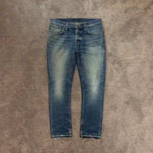Nudie Jeans - Nudie Jeans i modellen Grim Tim | Fint skick, lite slitningar som det syns på bilderna & ett hål i ena fickan men en riktigt snygg fade | Storlek: W32xL32 | Hojta till vid fundering