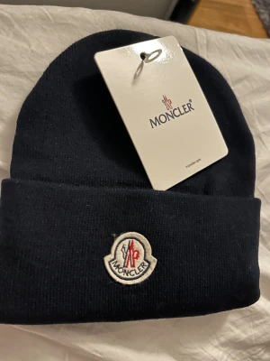 Moncler mössa  - Mycket bra skick! Perfekt nu till vintern, helt ny. Tags och allt finns kvar.