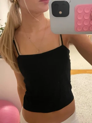 Svart linnetopp med smala axelband - Säljer ett snyggt svart linne med smala axelband från gina tricot! Jättebra skick! Knappt använd!