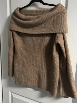 Off shoulder tröja  - Säljer en beige stickad tröja med  offshoulder-krage. Tröjan har långärmade och är ribbad och stickad. Tröjan är i storlek S men är lite oversized. 