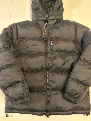 Svart pufferjacka från Polo Ralph Lauren - Helt ny svart pufferjacka från Polo Ralph Lauren. Passar både S och M skulle jag säga. Skriv vid intresse!