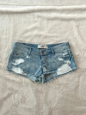 Hollister lågmidjade jeansshorts  - Ett par jeansshorts från Hollister i storlek W29, motsvarar en vanlig M. Rakt över midjemått: ca 41cm. Jag fraktar inom 24h. Se liknande plagg i min profil!