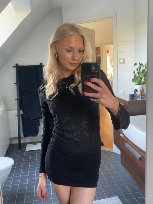 Svart festlig långärmad  - Säljer en svart långärmad meshtröja från Gina Tricot. Blusen är genomskinlig med ett snyggt blommigt mönster i tyget och har en tight passform. Perfekt att styla med kjol eller jeans för en trendig look. Endast använd en gång!💕