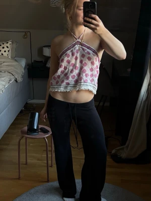 Prickig halterneck linnetopp - Supergullig vit och rosa halterneck linnetopp med stora prickar och dekorativt band upptill. Toppen har knyt i nacken, öppen rygg och fransig kant nertill. 