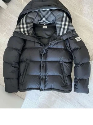 Svart pufferjacka från Burberry - Säljer en helt ny Burberry jacka som blir även till en väst oanvänd, Storlek S Fraktar snabbt inom 24h efter köp.Ställ gärna din fråga.. Perfekt för kalla dagar och riktigt snygg stil.