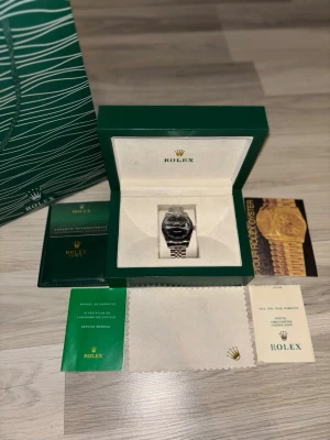 Lyxig Klocka - Jag säljer en lyxig och elegant klocka + tillbehör •Vara: lyxig klocka                                                           •Typ: Mörk grå urtavla med  romerska siffror •skick: väldigt bra                                              •Urtavla: 41mm                                                       •Band:Passar mig bra, kommer med 4 extra länkar •Leverans: skickar samma dag vid köp före 16:00 på vardagar och 12:00 på helger annars skickas det dagen efter. 