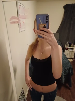 Svart linnetopp med spetskant - Säljer en svart linnetopp med smala axelband och snygg spetskant upptill. Skriv för fler frågor 