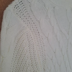Vit stickad tröja från LCW Casual - Säljer en vit stickad tröja från LCW Casual med klassiskt flätmönster och rund halsringning. Tröjan har lång ärm och bred ribbad mudd vid ärmslut och nederkant. Perfekt för kyliga dagar och enkel att matcha med jeans eller kjol.