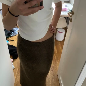 Brun stickad långkjol från Object - Mysig brun stickad långkjol från Object i storlek 36. Kjolen har en rak passform och är ribbstickad vilket ger en snygg struktur. Perfekt att styla med en enkel topp eller en oversized tröja för en chill look.