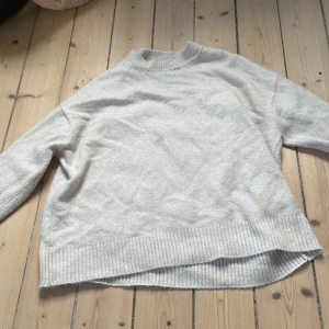 Beige stickad tröja från MNG - Supermjuk beige stickad tröja från MNG med ribbade muddar och högre hals. Perfekt för lager-på-lager och har en avslappnad passform med längre bakstycke. Enkel att matcha med jeans eller kjol för en chill look.