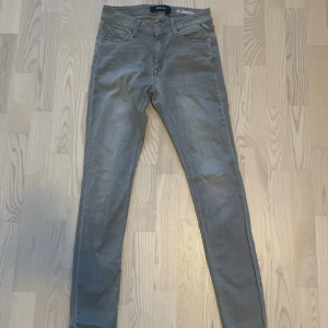 Replay jeans grå - Snygga grå jeans från Replay, Klassisk femficksdesign och dragkedjegylf. Jeansen är i stretchigt denim som sitter tight hela vägen ner. Perfekta för dig som gillar och vill ha en modern look.
