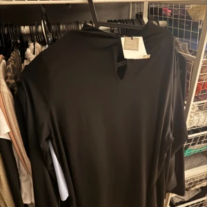 Svart långärmad klänning från BikBok - En stilren svart långärmad klänning från BikBok i storlek XS. Klänningen har en enkel och elegant design med rund halsringning och mjukt, följsamt material. Perfekt för dig som gillar minimalistisk stil och vill ha en klassisk svart klänning i garderoben.