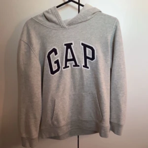 Grå hoodie från GAP  - Säljer den gråa hoodien från GAP då den är för kort i armarna för mig. Köptes på Vinted 