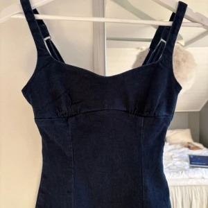 Mörkblå jeansklänning från Zara - Supersnygg mörkblå jeansklänning från Zara i figurnära modell. Aldrig använd och har prislappen kvar på. Tror den är ganska svår att få tag på då den inte säljs längre om jag kommer ihåg rätt! 