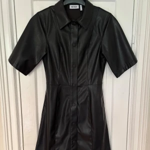 Skjortklänning Weekday - Säljer en svart skjortklänning (”Savanna Dress”) i läderimitation från Weekday. Endast använd två gånger. 🖤
