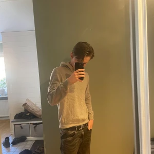 Kashmir hoodie från Oscar Jacobson XS - Säljer en stilren grå kashmir hoodie från Oscar Jacobson i storlek XS. Tröjan har huva, lång ärm och är tillverkad i mjukt material som känns skönt mot huden. Perfekt för dig som gillar en clean och enkel look.