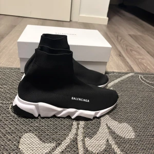 Balenciaga Speed Trainer sneakers svart - Säljer ett par Balenciaga Speed Trainer sneakers i svart med vit och svart chunky sula. Skorna har en strumpliknande passform i stretchigt syntetmaterial och Balenciaga-logga på sidan. Perfekta för dig som gillar en modern och sportig look.