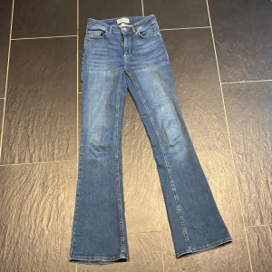 Blå bootcut jeans från ONLY, S/32 - Snygga blå jeans från ONLY i bootcut-modell med klassisk femficksdesign. Jeansen har normal passform och är tillverkade i ett stretchigt denimtyg som sitter skönt. Perfekta för dig som gillar en tidlös look med lite utsvängda ben.