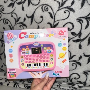 Educational Computer Toy lärplatta  - Färgglad pedagogisk leksaksdator för barn 3+ år med LED-skärm, tangentbord och pianotangenter. Perfekt för tidig inlärning och spel. Produkten är ny i förpackning, utan synligt slitage eller defekter. Kräver 3x AA-batterier (ingår ej).