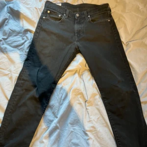 Levi's Premium svarta jeans straight fit - Svarta Levi's Premium jeans med klassisk femficksdesign och raka ben. Jeansen är tillverkade i ett mjukt och slitstarkt bomullstyg med en snygg, mörk tvätt. Passar perfekt till en avslappnad och stilren look.