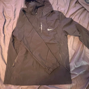 Svart Nike jacka S - Säljer en helt ny Nike jacka i storlek S. Svart med reflexdetaljer Aldrig använd – säljer då jag inte är i behov av den.