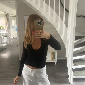 Svart ribbad topp med v-ringning - Snygg svart topp med v-ringning och långa ärmar. 