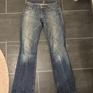 7 For all Mankind Jeans - Low waist bootcut 7 for all mankind jeans i storlek 26. Så fina och smickrande men tyvärr blivit för små för mig. Mycket bra skick! Midja: 38cm. Innerbenslängd: 83cm. Midjehöjd: 18cm. 