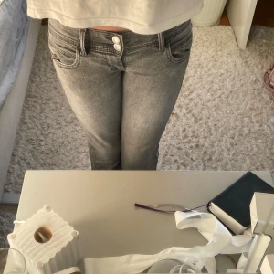 Grå jeans med stjärna på bakfickan👏🏼⭐️ - Säljer ett par grå jeans med snyggt slitna detaljer och en silverfärgad stjärna på bakfickan. Jeansen har låg midja och boodcut!💞 