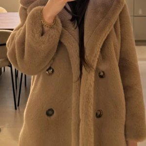 Beige pälsjacka med stora knappar från Malina - Fuskpäls kappa från Malina. En supermjuk och fluffig beige pälsjacka med bred krage och dubbelknäppning framtill. 
