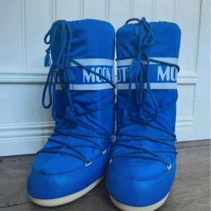 Blå Moon Boots med snörning - Ett par blå Moon Boots i storlek 37-39 (även fast det bara står 37 i beskrivningen), dem är i fint skick och endast använda ett fåtal gånger!