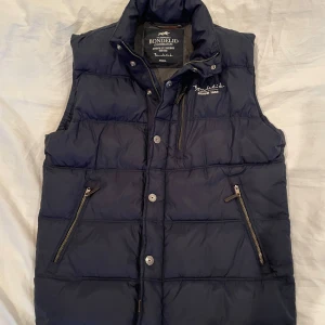 Bondelid väst - Säljer denna riktigt snygga Bondelid Väst i navy blue. Storleken är Small och passar perfekt nu när vädret börjar bli lite kylare. Perfekt med en hoodie under. Skick 8/10