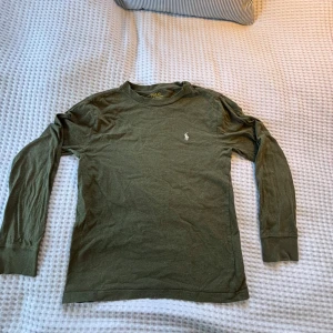 Olivgrön långärmad tröja Polo Ralph Lauren - Snygg olivgrön långärmad tröja från Polo Ralph Lauren med klassisk broderad logga på bröstet. Passar dig som är runt 150, perfekt för hösten/ vintern. Hör gärna av dig vid intresse för fler bilder eller frågor😊