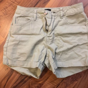 Beige jeansshorts från Vero Moda XS - Snygga beige jeansshorts från Vero Moda i klassisk femficksmodell. De har uppvikta benslut, bälteshällor och stängs med knapp och dragkedja. Perfekta för varma dagar och enkla att matcha med allt.