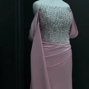 Glittrig damrosa långklänning med pärlor - Superfin långklänning i ljusrosa med glittrig, pärlbeströdd överdel och offshoulder-ärmar. Kjolen är draperad och har en elegant, slät finish. Perfekt för bal eller fest där du vill sticka ut och glänsa. Vid intresse skriv privat. Storlek 34/38